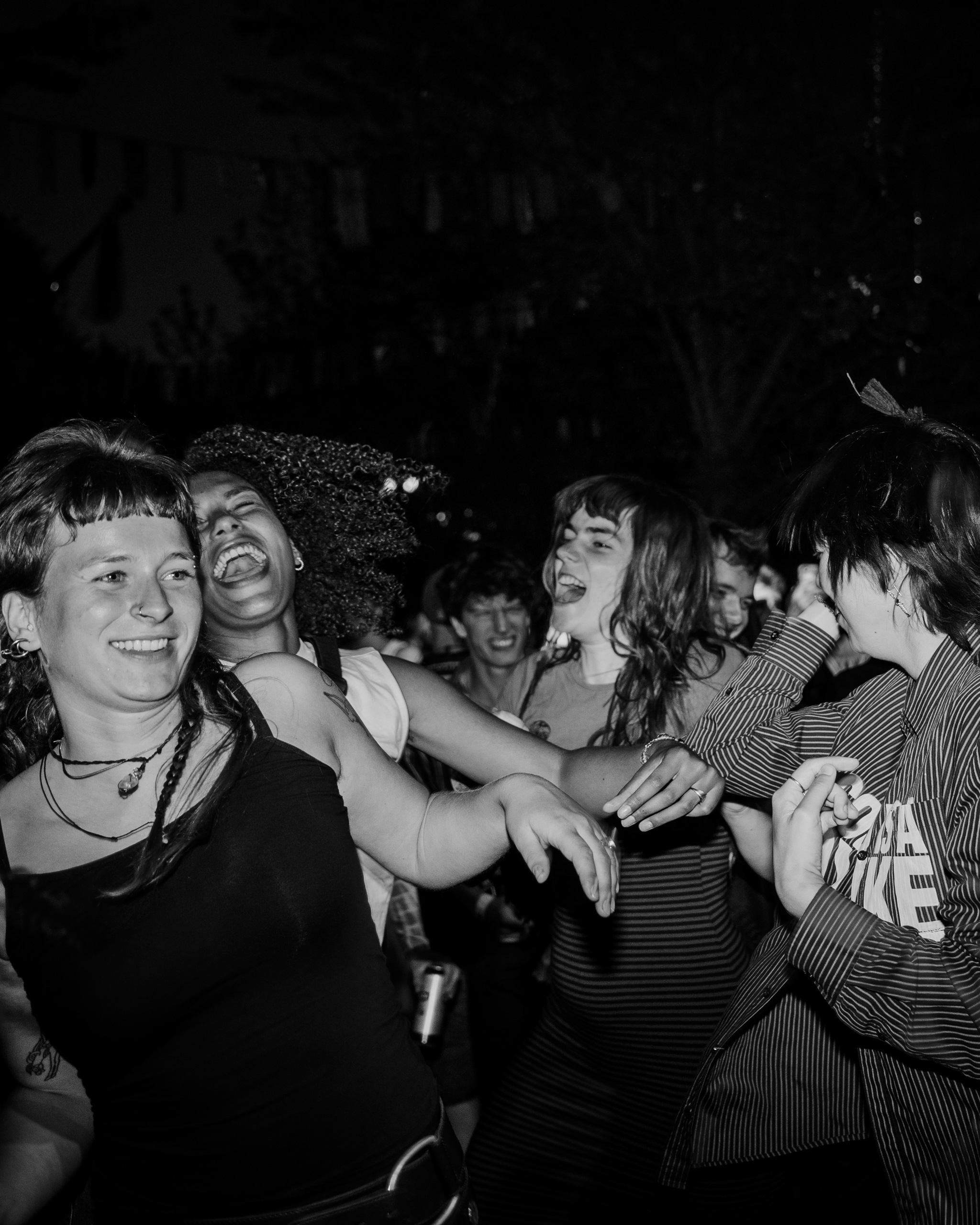 A black and white photo of a FLINTA* crowd moshing at a punk rock show
